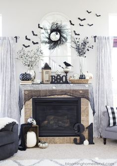 a living room decorated for halloween with black and white decorations on the fireplace mantel