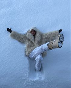 a person laying down in the snow with their legs spread out and feet propped up