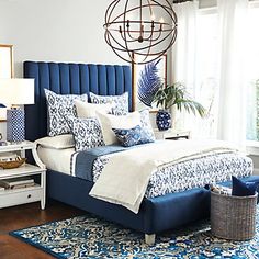 a bedroom with blue and white decor on the bed