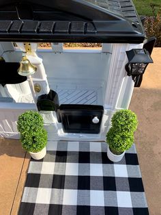 a black and white checkered rug with potted plants in the back of a truck