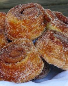 some sugared doughnuts are piled on top of each other