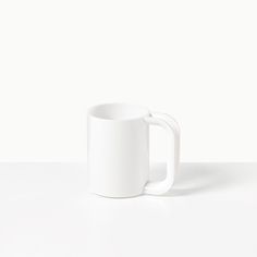 a white coffee mug sitting on top of a table