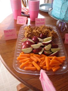 there are many different fruits and vegetables on the table with name tags attached to them