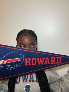 a woman holding up a baseball bat with the word howard written in red, white and blue on it