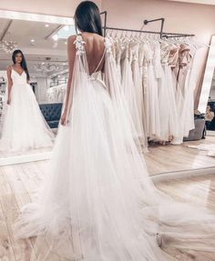 the back of a woman's wedding dress in front of a mirror with her reflection