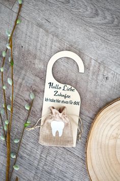 a wooden sign with a tooth on it next to a plant and a piece of wood