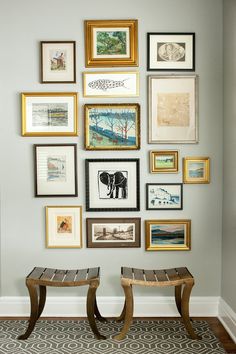 two benches sitting in front of a wall with pictures on it