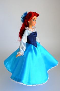 a doll with red hair wearing a blue dress