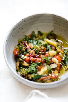 a white bowl filled with vegetables on top of a table