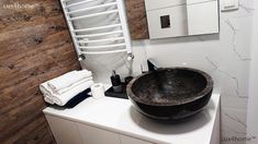 a black bowl sink sitting on top of a white counter next to a towel rack