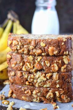 three pieces of banana nut bread stacked on top of each other with bananas in the background