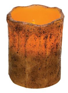 an orange candle that is sitting in front of a white background with dirt on it