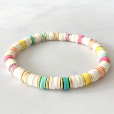 a white bracelet with multi colored beads