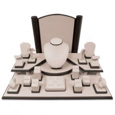 a white vase sitting on top of a table surrounded by black and white plates, cups and saucers