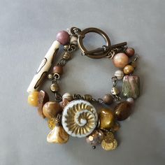 a close up of a bracelet on a table with beads and other items attached to it