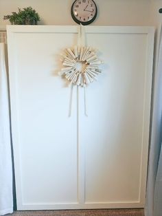 a clock mounted to the side of a white door in a room with carpeted flooring