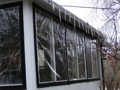 icicles hanging from the roof of a house next to a tree with no leaves