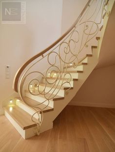 a white staircase with lights on the bottom and handrail