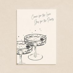 two martini glasses sitting next to each other on top of a card that says, come for the love see for the party