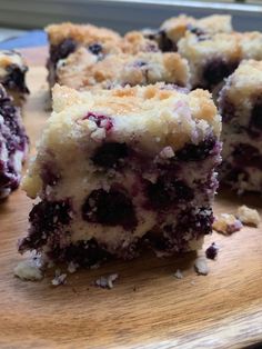 blueberry crumb bars cut into squares on a cutting board, ready to be eaten