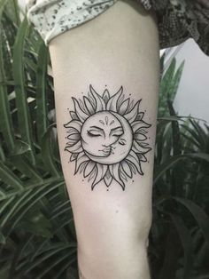 a woman's arm with a sun tattoo on it