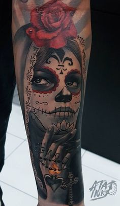 a woman's leg with a skull and rose tattoo on it