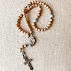 This handcrafted, beautiful, and unique Catholic rosary is made with 8mm rosewood wood beads and 8mm aquamarine beads. The beads are strung and knotted on micro cord (the slimmest type of paracord!) for durability.The solid bronze rosary center depicts Stella Maris, Our Lady Star of the Sea. The solid bronze crucifix is 1.5 inches in length and is a hand cast antique reproduction. This rosary is about 13 inches in length and is lightweight and easy to carry with you so you can “pray without ceas Adjustable Wooden Beads Spiritual Rosary, Adjustable Crucifix Jewelry With Wooden Beads, Adjustable Natural Stones Rosary For Meditation, Adjustable Wooden Bead Crucifix Jewelry, Handmade Brown Rosary For Healing, Spiritual Brown Rosary For Healing, Star Of The Sea, Stella Maris, Beautiful Prayers