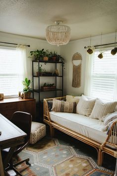 a living room filled with furniture and a chandelier hanging from the ceiling next to windows