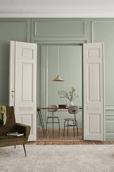 a living room with green walls and white doors