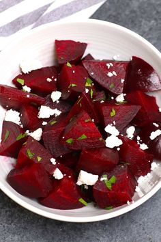 a white bowl filled with beets and feta cheese on top of a table