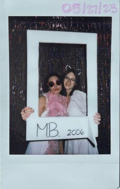 two women pose for a photo in front of a mirror with the words mr and mrs 2006 written on it