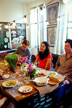 a group of people sitting around a table with food and drinks in front of them