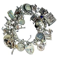 An outstanding vintage sterling silver charm bracelet loaded with silver charms. This bracelet has been built upon over many years and boasts a really impressive and unique array of different charms. It is built upon a chunky silver curb bracelet, the bracelet fastens with a heart shaped padlock fastener and has a fine link safety chain. The Charms all vary in size and age from 60s to the 90s, many marked for silver. There are 30 charms and some really interesting ones, some of our favourite ones include a flying fish, ship in a bottle, rocking chair, policeman's helmet and a lucky horseshoe There is one silver plated charm and a few coin charms too. Marks and era: The padlock is marked silver, bracelet tests as sterling silver, most charms are marked for sterling silver or 800 silver, the Vintage Sterling Silver Bracelet With Charm, Sterling Silver Vintage Charm Bracelet, Silver Vintage Bracelets With Vintage Charm, Heirloom Silver Bracelet With Vintage Charm, Silver Heirloom Jewelry With Vintage Charm, Heirloom Silver Jewelry With Vintage Charm, Sterling Silver Bracelets With Dangling Charms For Collectors, Vintage Hallmarked Sterling Silver Charm Bracelet, Collectible Silver Bracelet With Vintage Charm