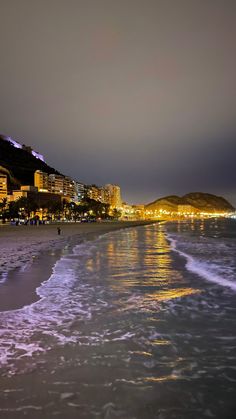 the beach at night with buildings in the background