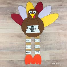 a turkey made out of construction paper on top of a wooden table with the words i am