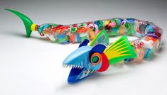 an assortment of colorful toothbrushes in a plastic fish tube on a white surface