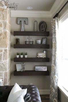 a living room filled with lots of shelves next to a wall covered in pictures and photos