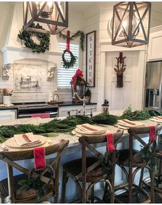 a kitchen decorated for christmas with wreaths and greenery