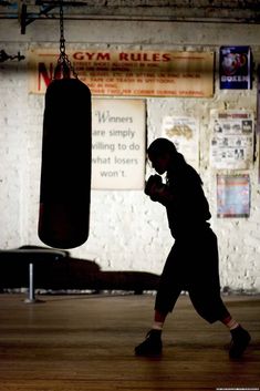 a man standing in a gym with a punching bag