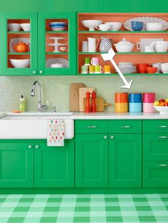 a kitchen with green cabinets and checkered flooring on the floor is painted in bright colors