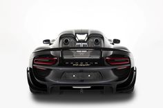 the rear end of a black sports car with eyes on it's head and tail