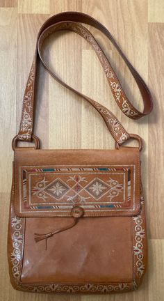 a brown purse sitting on top of a wooden floor