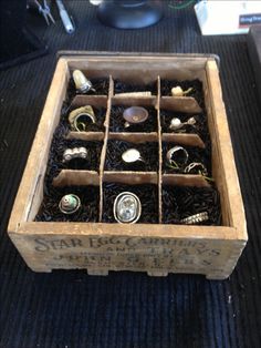 an old wooden box filled with lots of different types of buttons and magnets in it