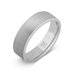 a white gold wedding ring with an engraved cross on the center and a satin finish