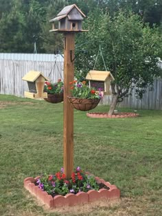 a wooden pole with two hanging bird houses and flower pots on it's sides