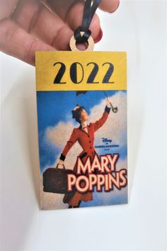 a person holding up a small card with the name mary poppin's on it