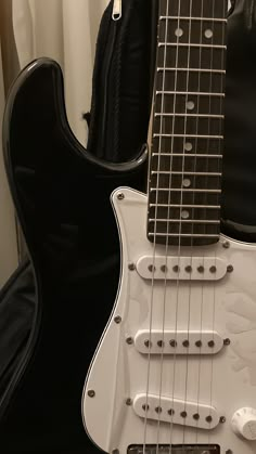 a white electric guitar sitting on top of a black case