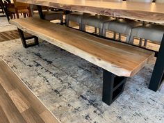 a wooden table and bench in a room with hardwood flooring on the side, surrounded by chairs