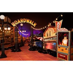 the entrance to boardwalk at night with lights and signs on it's sides,