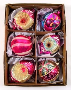 six christmas ornaments in a box on a table